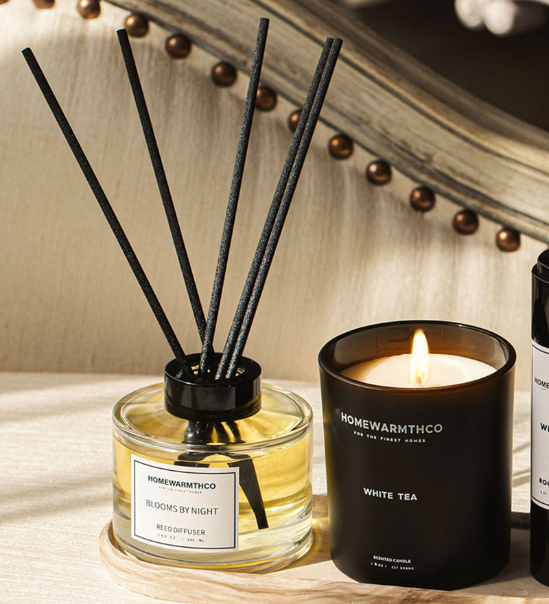 Homeware items including a diffuser and candle on a wooden surface.