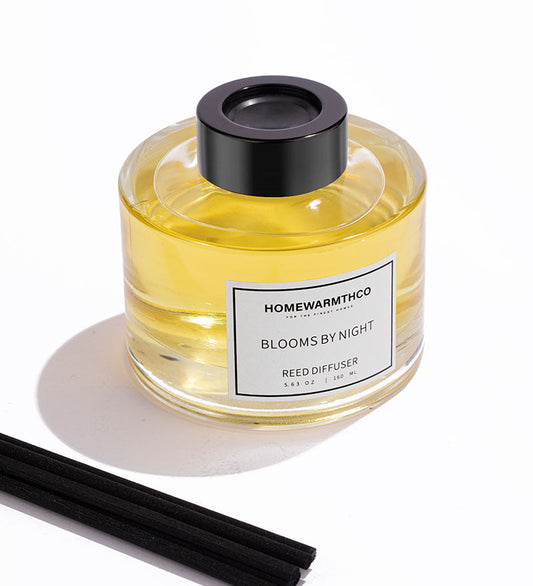 Homewarmthco reed diffuser with black cap and sticks on a white background