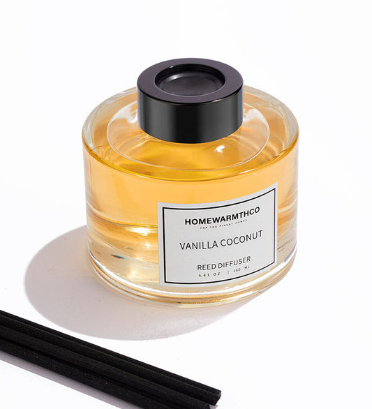 Vanilla Coconut reed diffuser with black cap and sticks on a white background