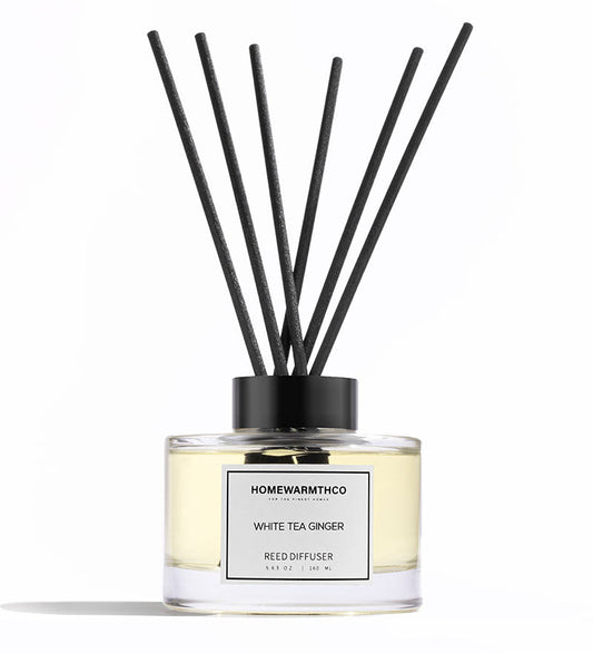 Reed diffuser with black sticks and a visible label on a white background