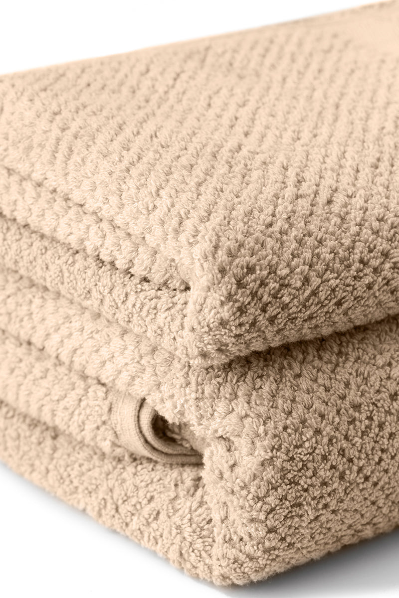 Beige folded towel on a white background