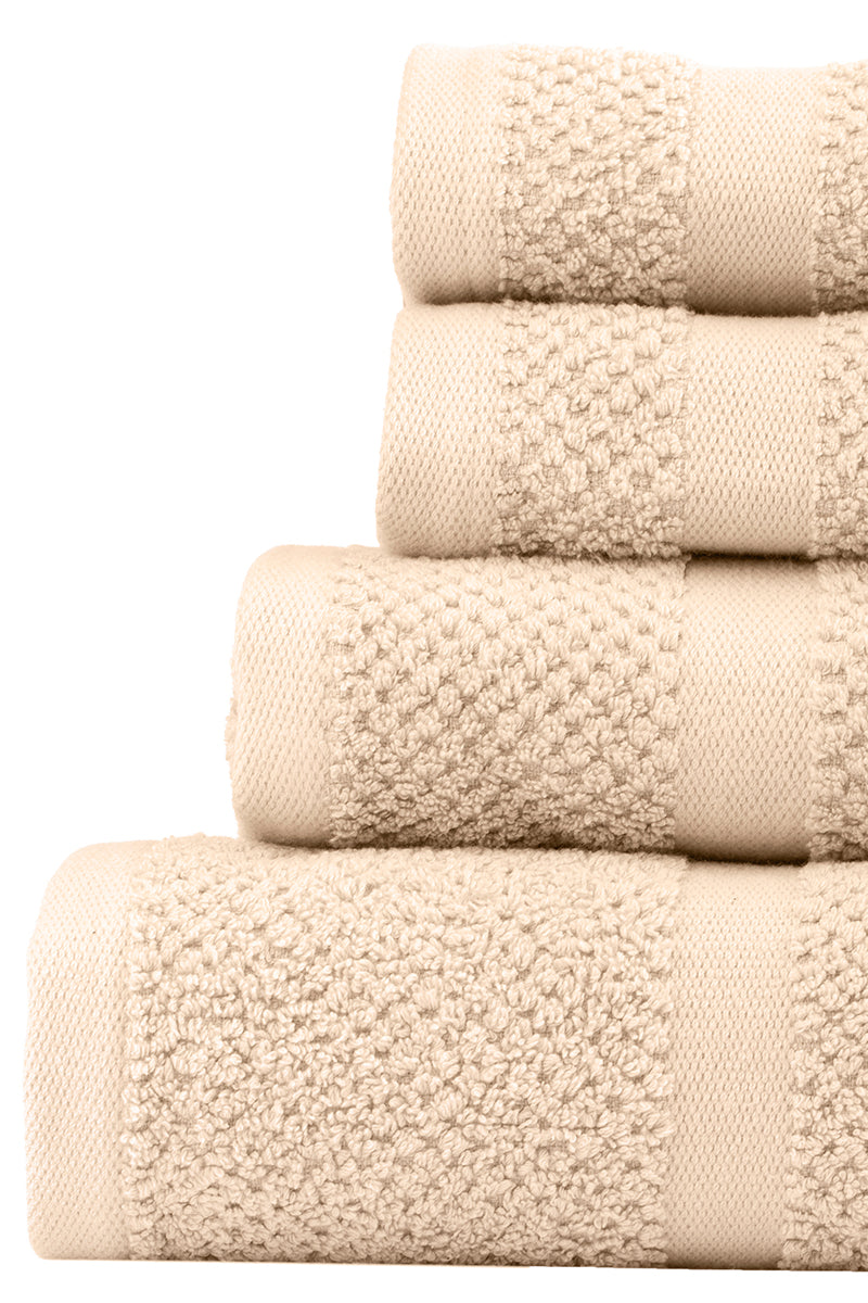 Stack of beige towels with textured surface on a white background