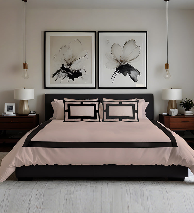 Neatly made bed with pink bedding and black accents in a bedroom setting.