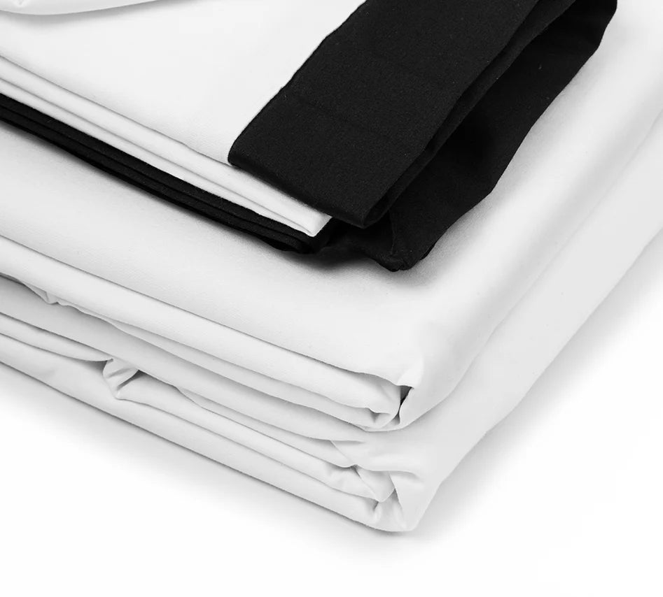 Stack of folded white and black fabric on a light gray background
