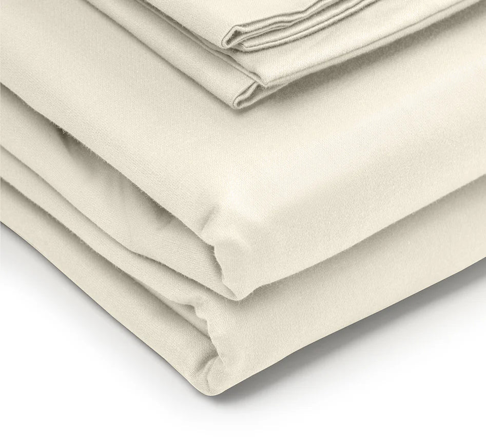 Folded beige bed sheets on a white background