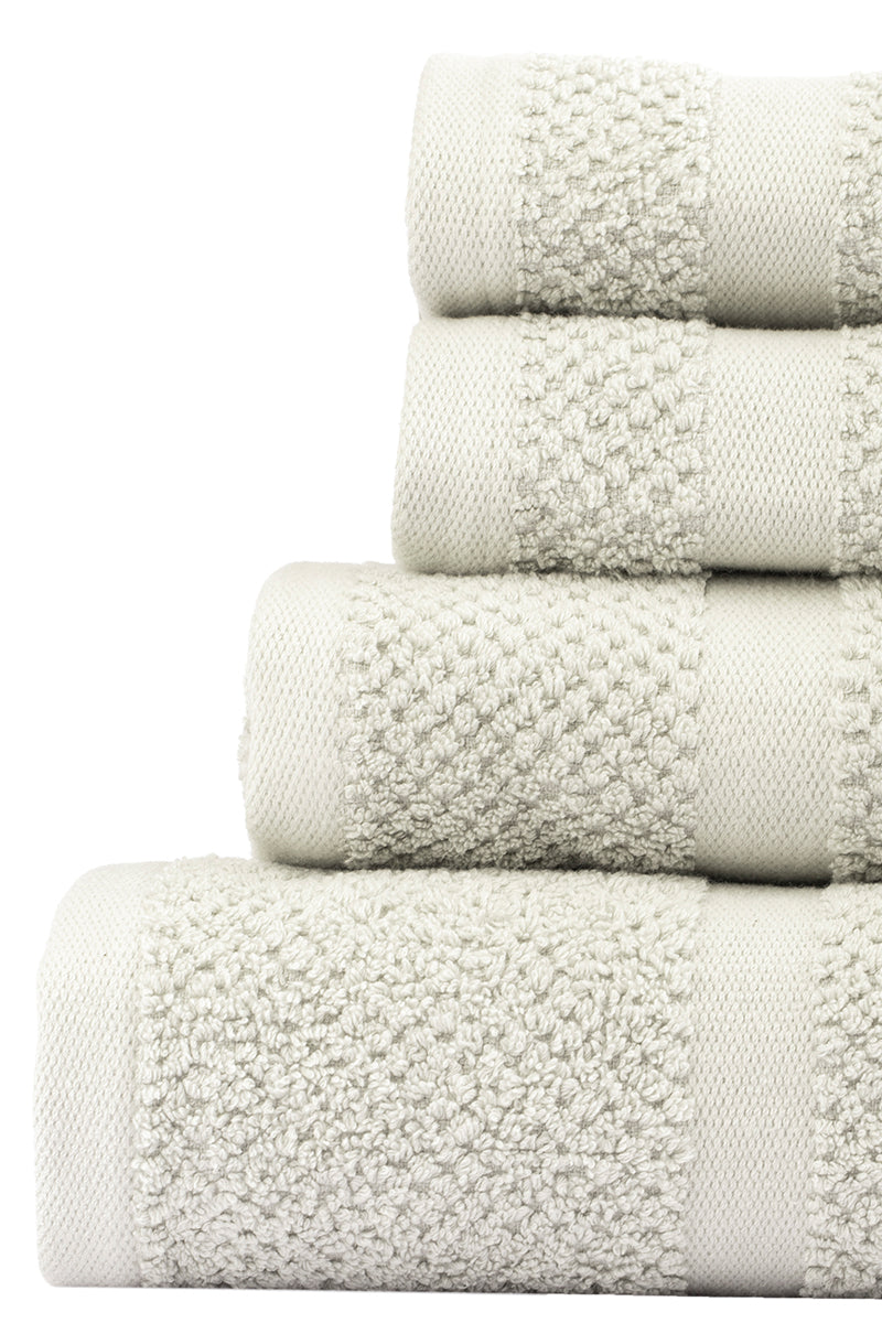 Stack of white textured towels on a white background