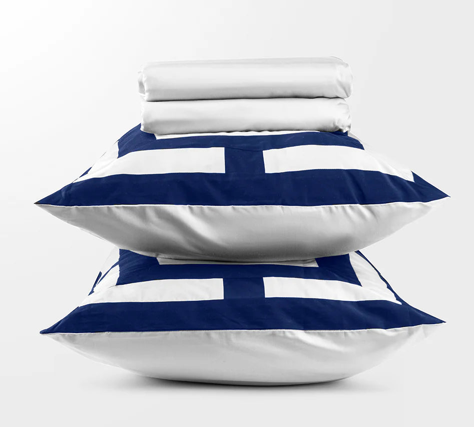 Stack of folded white bedding with blue and white striped pillowcases on a white background