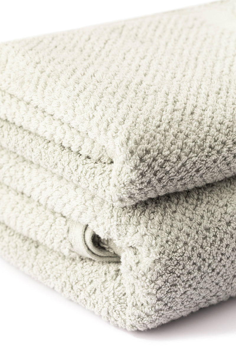 Stack of folded beige towels on a white background