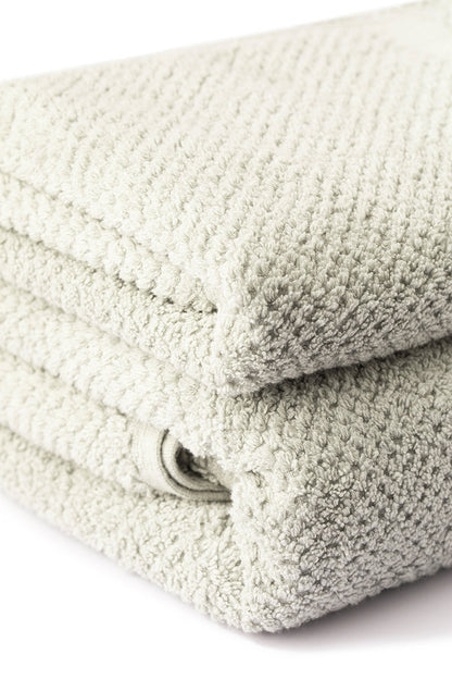 Stack of folded beige towels on a white background
