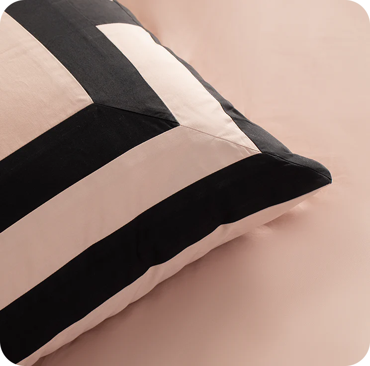Close-up of a striped pillow with black, white, and beige colors on a beige background.