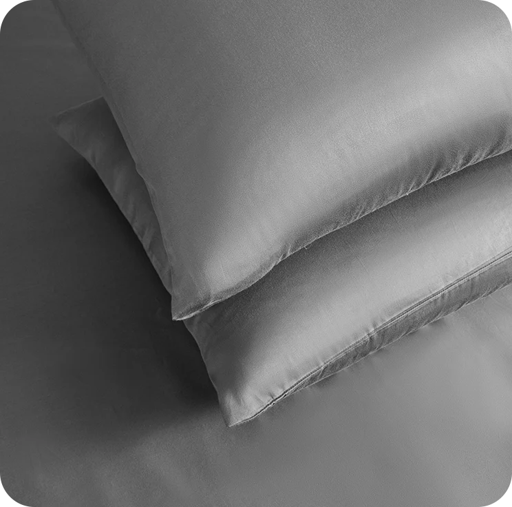 Two gray pillows stacked on top of each other with a soft texture.