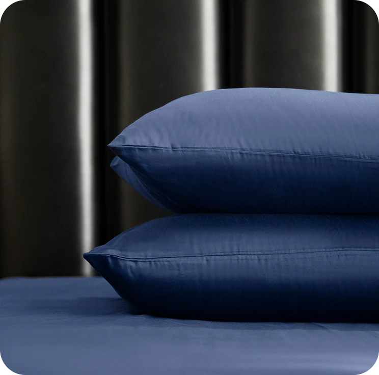 two pillows on bedsheet with a dark background