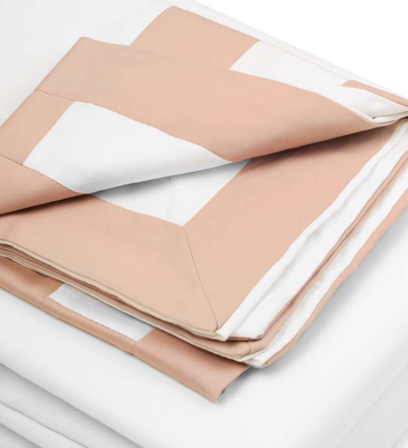 Folded beige and white fabric on a light gray background
