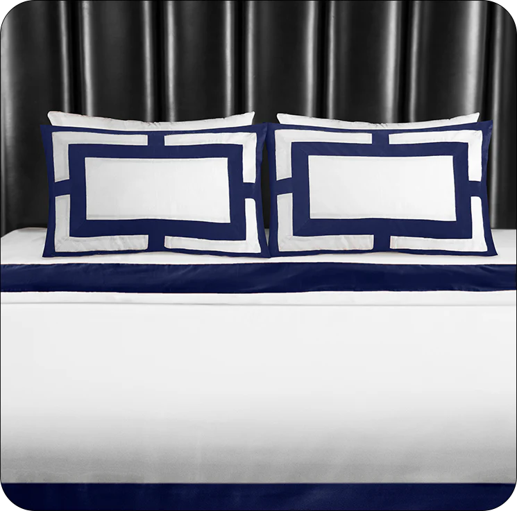 Navy and white checkered pillows on a bed with a dark headboard.