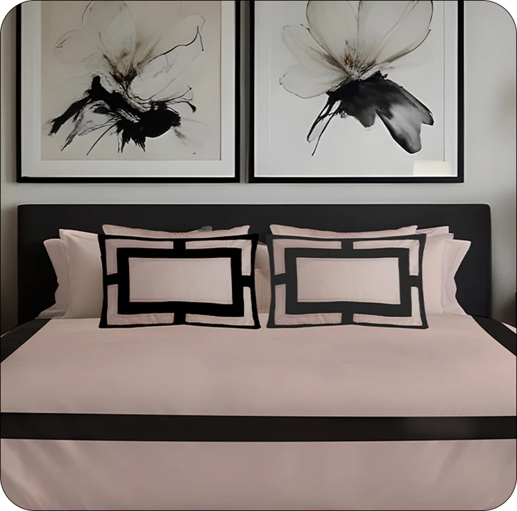 Bed with black and white geometric pillows and abstract wall art above.
