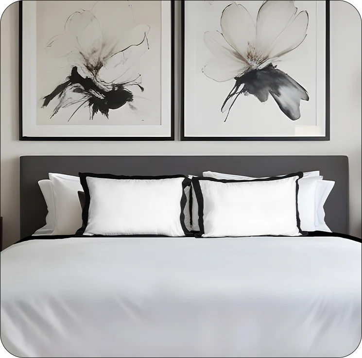 Bedroom with white bedding and black and white abstract floral artwork on the wall.