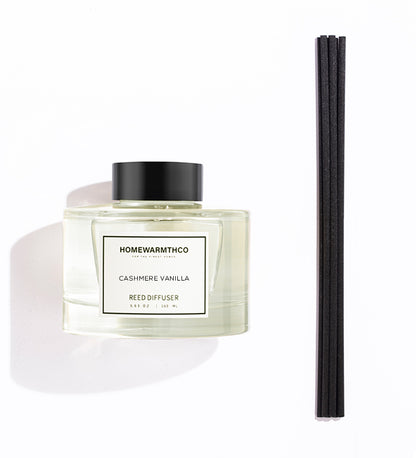 Homewarmthco Cashmere Vanilla reed diffuser with black cap and three black reeds on a white background
