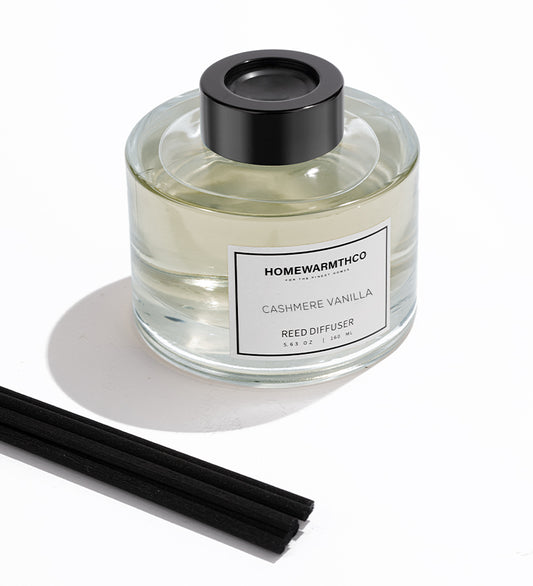 Homewarmthco Cashmere Vanilla reed diffuser with black cap and sticks on a white background