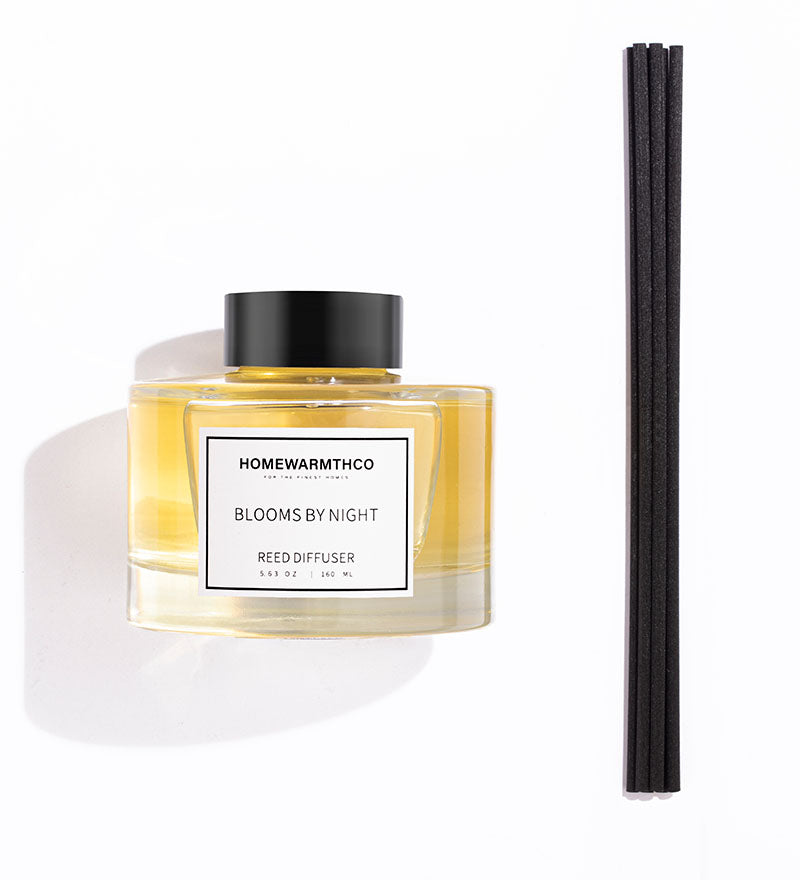 Homewarmthco reed diffuser with black cap and white label on a white background