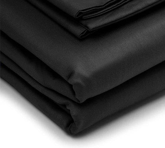 Folded black bedsheet fabric on a white background