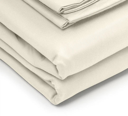 Folded beige bed sheets on a white background