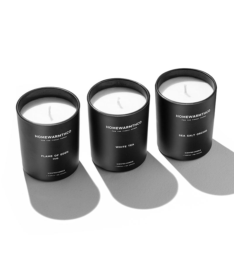 Three HomewarmthCo candles on a white background