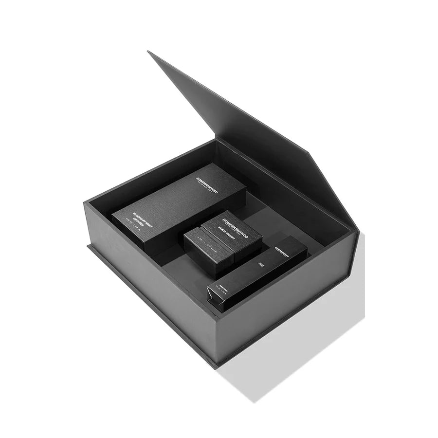 Black open box with diffuser, room spray, candles inside on a white background