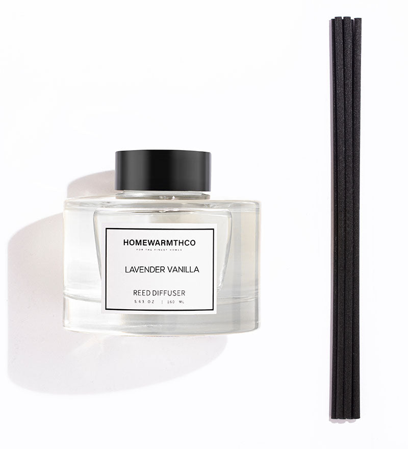 Homewarmthco lavender vanilla reed diffuser with black reeds on a white background