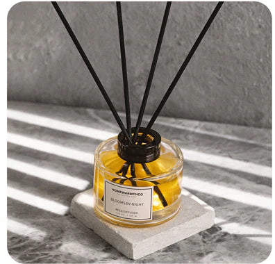 Reed diffuser with black sticks on a gray marble surface