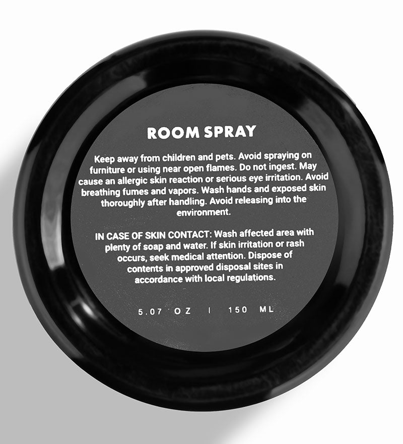 Black room spray container with safety information on a white background