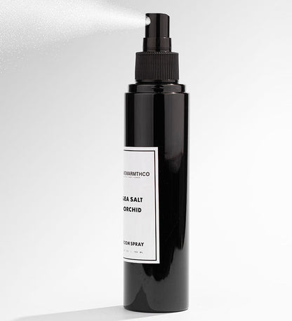 Black spray bottle with a label on a white background