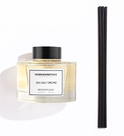 Homewarmthco Sea Salt Orchid reed diffuser with black sticks on a white background