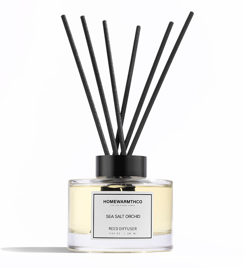 Reed diffuser with black sticks and a clear bottle labeled 'Homewarmthco' on a white background