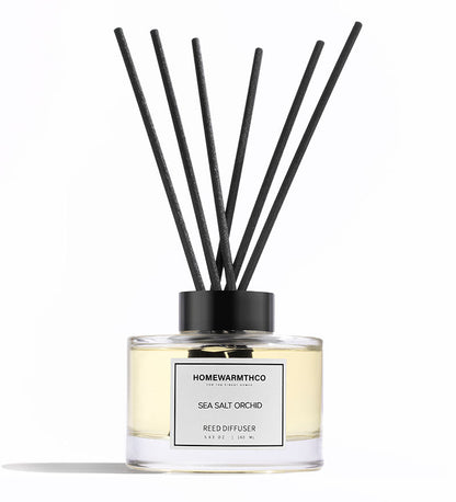 Reed diffuser with black sticks and a clear bottle labeled 'Homewarmthco' on a white background