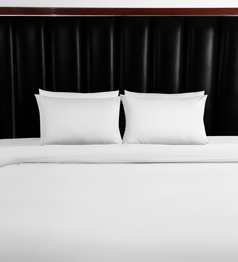 White pillows on a bed against a black headboard