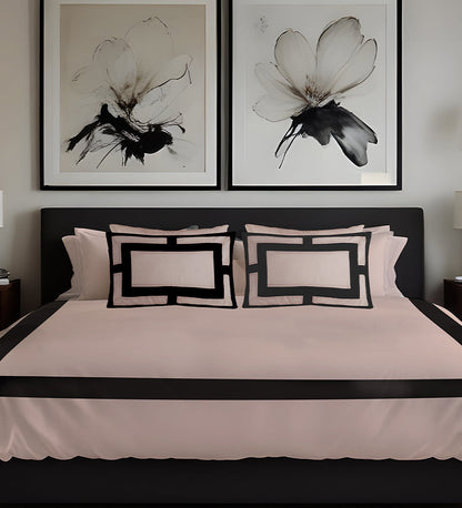 Bedroom with black and white floral artwork above a bed with matching pillows.
