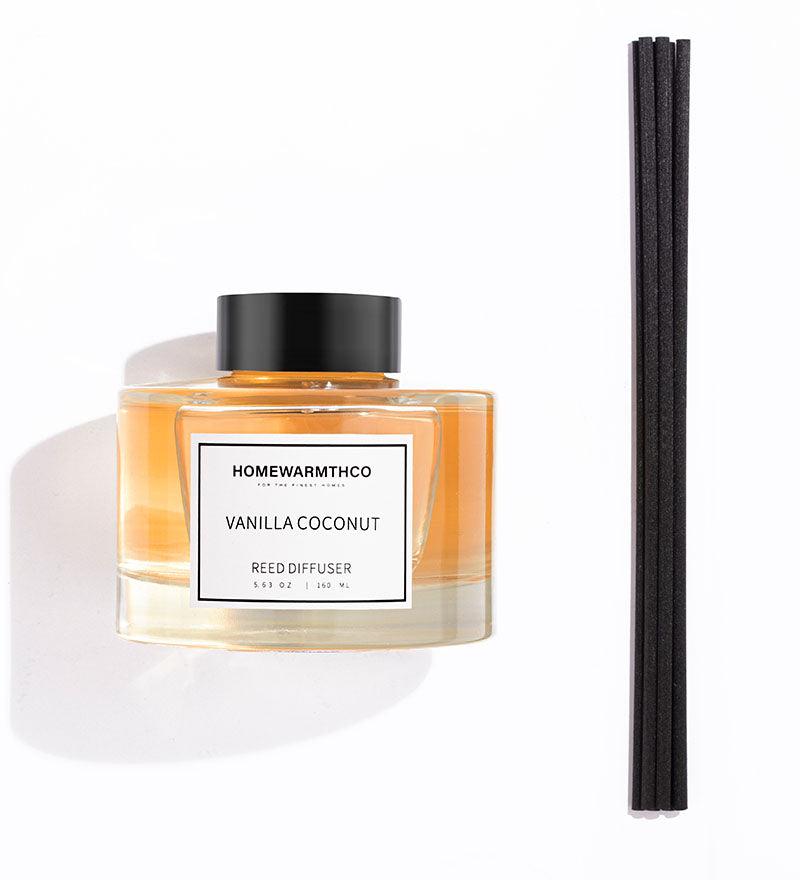 Homewarmthco Vanilla Coconut reed diffuser with black reeds on a white background
