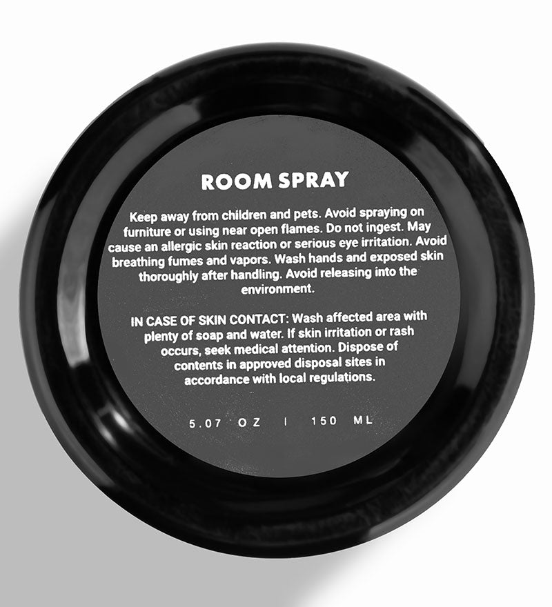 Black room spray container with safety information on a white background