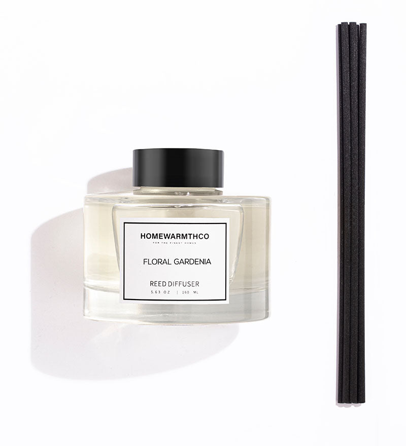 Homewarmthco floral gardenia reed diffuser with black cap and reeds on a white background
