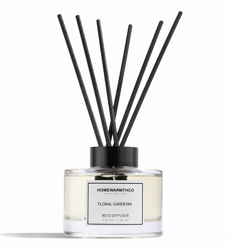 Reed diffuser with black sticks and white label on a white background