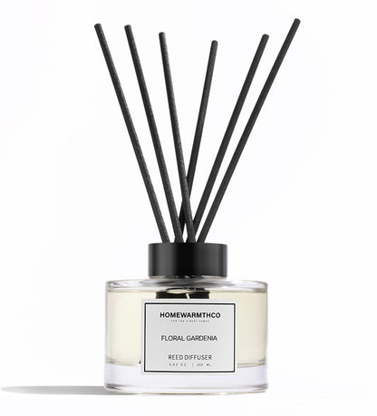 Reed diffuser with black sticks and white label on a white background