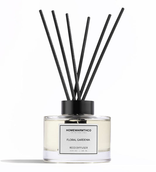 Reed diffuser with black sticks and white label on a white background
